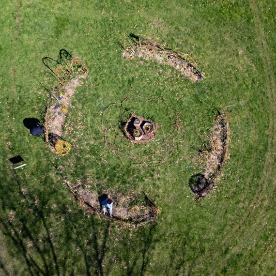 An overhead photo captures a circular design of the living sculpture on green grass.